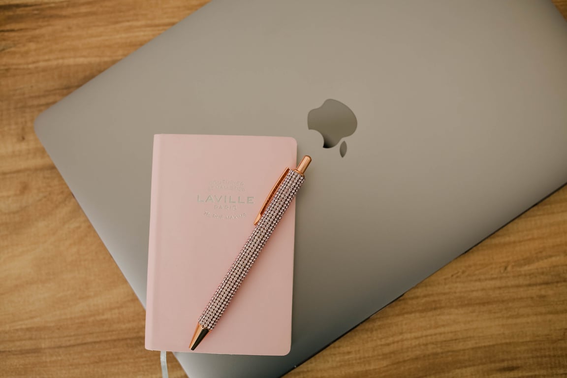 Close Up Photo of Pink Notebook and a Laptop